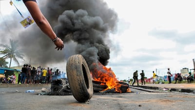 A man rolls a tyre onto a burning barricade, on a street in Mozambique's capital Maputo, during post-election protests. EPA