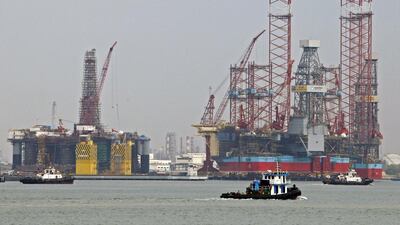 Tugboats pass jack-up rigs at a Keppel shipyard in Singapore. Edgar Su / Reuters
