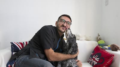 Samer Alogidi, the owner Pooch Parlour in Abu Dhabi, with one of his regulars, Hunter, a 14-year-old American Cocker Spaniel. Mona Al Marzooqi / The National