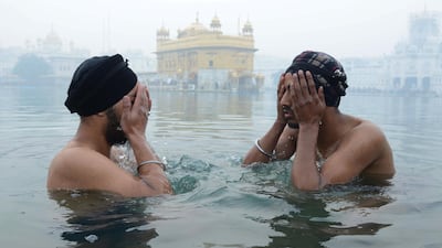Indian Sikh devotees take a dip in the holy sarovar in the early morning on the occasion of the New Year at the Sikh shrine Golden Temple in Amritsar. AFP