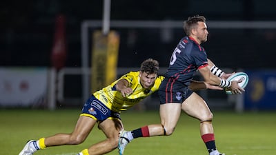Conor Kennedy of Dubai Exiles is challenged by Matt Gilham of Dubai Hurricanes.