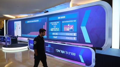 An employee of the Israel Central Elections Committee walks past a large screen that shows live results at the counting headquarters in the Israeli parliament Knesset in Jerusalem, 28 October 2026. The Israel Central Elections Committee is the final stage of counting the votes of the Israel legislative election day results. As the country is in a political deadlock, what appears to be a tie between the Netanyahu bloc and the opposition bloc. EPA / ABIR SULTAN