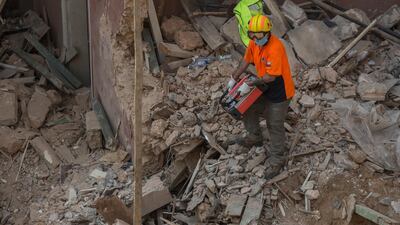 A Chilean rescue worker uses a sensitive listening device to locate vital signs of a survivor at a site of the Beirut blast in Beirut, Lebanon. A sniffer dog with a Chilean rescue crew responded to the presence of a person in the rubble of a building damaged in the deadly explosion on August 4. The condition of the person is unknown. Getty Images
