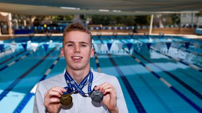 Lewis Burras, a sixth-form pupil at JESS School Dubai, shows off his medals from the recently concluded British Swimming Championships. Victor Besa / The National