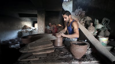 An Egyptian worker shapes a clay ornament at one of the traditional pottery workshops, in Old Cairo, Egypt.