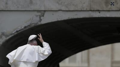 Pope Francis tries to hold on to his skull cap at a windy St Peter’s Square in Vatican City. Alessandra Tarantino / AP Photo