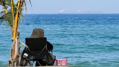A woman sits along a beach off the Gulf of Oman in Fujairah. AFP