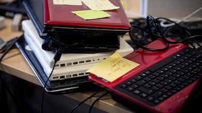 Donated computers with notes marking their faults are seen on a workbench at Catbytes. In a community centre in London, volunteers take screwdrivers to piles of laptops and check they are operating well. The computers donated by members of the public will go to children whose families do not have the laptops they need to take part in lessons online. AFP