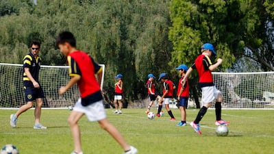 Pupils learn football skills outdoors at Jebel Ali Primary in Dubai. Sarah Dea / The National