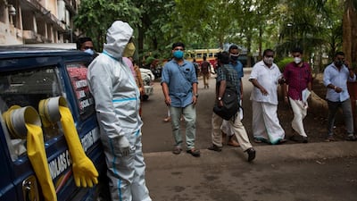 A man in protective suit stands next to a mobile testing kiosk outside the Ernakulam district administration headquarters in Kochi, Kerala, India. AP Photo