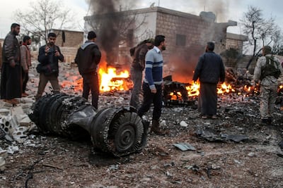 People walk amidst the rubble of the Russian Sukhoi Su-25 fighter jet scattered on the ground, in Ma'saran village near Saraqeb city, in Eastern Idlib countryside. Abdalla Saad/ EPA