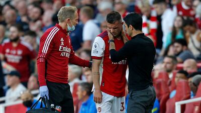 Arsenal's Swiss midfielder Granit Xhaka is spoken to by manager Mikel Arteta after getting injured during the match against Tottenham Hotspur at the Emirates Stadium on Sunday, September 26. AFP
