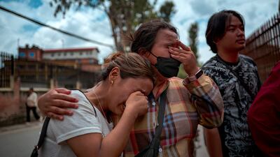 KATHMANDU, NEPAL - AUGUST 29: Women cry as they view photographs of bodies recovered after the floods, displayed outside Maharajgunj Medical Campus where unidentified bodies are being taken, on August 29, 2026 in Kathmandu, Nepal. A sudden flood swept through the Bhote Koshi River basin in northern Rasuwa on August 26, damaging settlements, roads and energy infrastructure as rescue teams searched for residents and foreign travellers reported out of contact. Hundreds were reported missing, as the death toll started to climb. (Photo by Ezra Acayan / Getty Images)