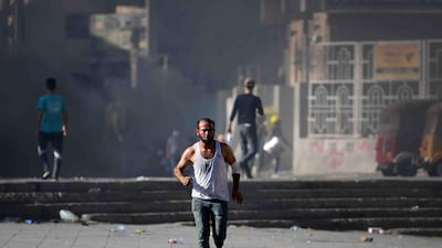 A protester runs to safety during clashes between protesters and riot police forces in Al Rasheed street, near the Al Tahrir square in Baghdad. EPA