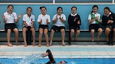 Grade 5 Repton School students watch Edward Hawkins complete a lap.