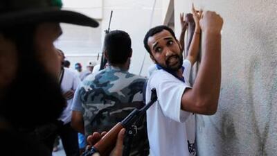 Libyan rebel fighters stand guard over detainees during a fight for the final push to flush out Muammar Gaddafi's forces in Tripoli. Reuters