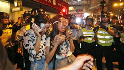 Student protesters cry as some are beaten by riot police in the occupied area in the Mong Kok district. Kin Cheung/ AP Photo
