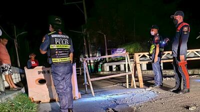 Police officers stand guard on a road closed due to cracks following an earthquake in Ilocos Norte Province, Philippines October 25, 2022, in this handout image obtained by Reuters. Philippine Bureau of Fire Protection/Handout via REUTERS ATTENTION EDITORS - THIS IMAGE HAS BEEN SUPPLIED BY A THIRD PARTY. MANDATORY CREDIT. NO RESALES. NO ARCHIVES.