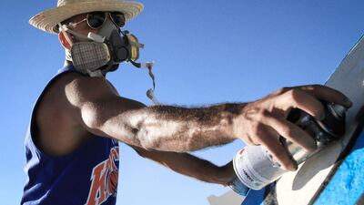 Photos of El Seed from his upcoming book, Lost Walls. at work spray painting in Tunisia. CREDIT: Courtesy El Seed