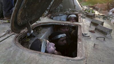 Rebel fighters sit inside an armoured vehicle during what they said was an offensive to take the Syrian city of Idlib on March 24, 2015. Khalil Ashawi / Reuters