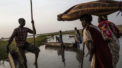 A young South Sudanese boat driver waits for passengers to board to cross Lake Yirol, on their way to reach the village of Pankar, South Sudan, on February 16, 2014. Fighting between forces loyal to South Sudanese president Salva Kiir and former vice president Riek Machar erupted on December 15, sparking heavy clashes across the country that have left thousands dead and displaced close to 900,000 people. Fabio Bucciarelli / AFP photo