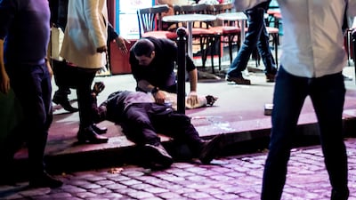 A man lies on the pavement near the cafe "A la Bonne Biere" in Paris, on November 13, 2015, following a series of coordinated attacks in and around Paris which left more than 120 people dead. The US state department have placed the man suspected of being the mastermind behind the attack on a terror list. Anthony Dorfmann / AFP The