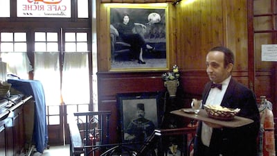 A waiter walks in front of a picture of Egyptian singer Umm Kulthum at the historical Cafe Riche in Cairo in 2021. AFP