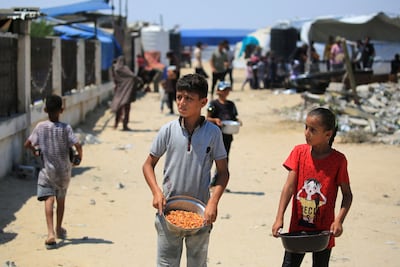 Displaced children receive food in Khan Younis. AFP