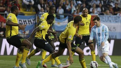 Lionel Messi dribbles into a crowd of defending Jamaica players during a Copa America group match in the summer. Natacha Pisarenko / AP / June 20, 2015