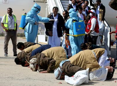 Prisoners from the Saudi-led coalition pray as they arrive following their release in a prisoner swap, at Sayoun airport, Yemen October 2020. REUTERS