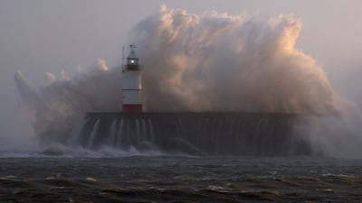 Waves crash over Newhaven Lighthouse. AFP