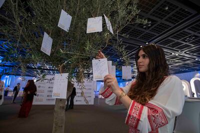 People write messages of support at a fund-raising event in aid of the Gaza in Our Hearts project at Dubai World Trade Centre in 2024. Leslie Pableo for The National