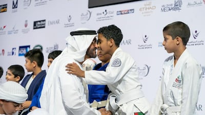 Sheikh Mohammed bin Zayed Al Nahyan Crown Prince of Abu Dhabi Deputy Supreme Commander of the UAE Armed Forces (L), greets a young participant during the Abu Dhabi Jiu-Jitsu Festival. Mohamed Al Hammadi / Crown Prince Court - Abu Dhabi