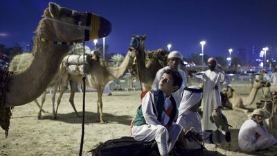 A young Emirati boy sits on a camel while waiting for the 42nd National Day celebrations to begin on Flag Island. Antonie Robertson/The National