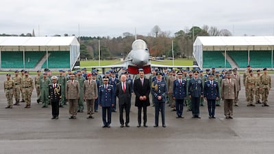 UK's Secretary of State for Defence John Healey and Sheikh Tamim pose with military personnel in front of a Eurofighter Typhoon jet. Reuters