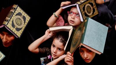 Worshippers with copies of the Quran on their heads