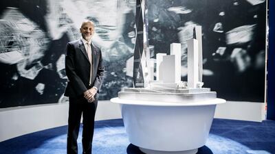 Dubai MultiCommodities Centre chief executive Gautam Sashittal with a model of the Burj2020 towers on display at Cityscape Global in Dubai. Reem Mohammed / The National