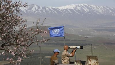 UN members look through binoculars as they monitor the Israel-Syria border in the Israeli-annexed Golan Heights on February 10, 2018. Jalaa Marey / AFP