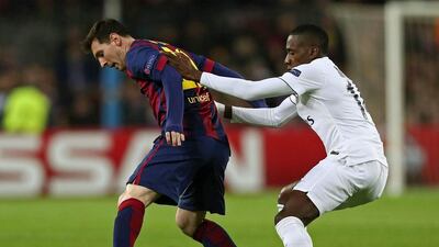 Paris Saint-Germain’s Brazilian midfielder Lucas Moura, right, battles for the ball with Barcelona’s Argentine forward Lionel Messi during their Uefa Champions League match. Toni Albir / EPA