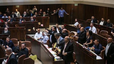 Arab lawmakers stand up in protest after Israel's parliament approved a controversial nation state law. Olivier Fitoussi / AP