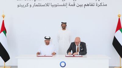Abdulla bin Touq, Minister of Economy, looks on as Abdullah Al Saleh, undersecretary of the Ministry of Economy, and Stuart Isted, managing director of Middle East and Africa at Crypto.com, sign an agreement between Investopia Summit and the cryptocurrency platform. Photo: Minister of Economy