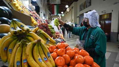A vendor arranges fruit on display at Kuwait City's Souk Al Mubarakiya. EPA