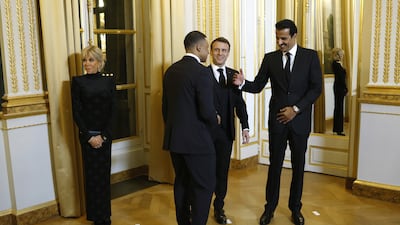 Sheikh Tamim is pleased to greet Mbappe as Mr Macron and his wife watch on. EPA