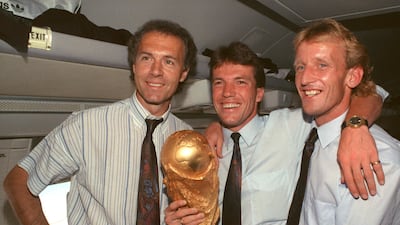 Germany manager Franz Beckenbauer, left, stands with midfielder and captain Lothar Matthaus, centre, and defender Andreas Brehme in the cabin of an airplane with the World Cup trophy in 1990. Getty Images