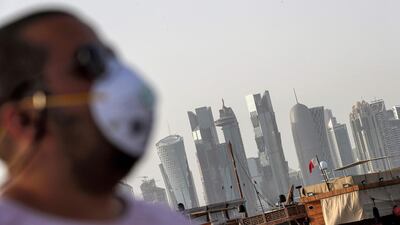 A man wearing a mask as a precaution against Covid-19 walks along the Doha corniche in the Qatari capital. AFP