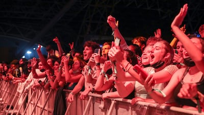 Audience members wearing masks cheer during the rapper's performance.