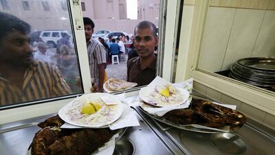 Staff collecting the fish dishes to serve customers, most of the staff are from Kerala in India.