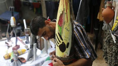 Palestinian artist Mohammed Al Zamar adorns a diffused ammunition round at the Bureij refugee camp in central Gaza. During the seven-week war which ended on August 26, the Israeli army fired countless missiles and tank shells at Gaza. Mohammed Abed/AFP Photo