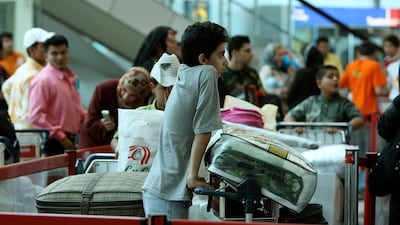 Passengers wait to check-in area at Sharjah International Airport. Employees who terminate contracts because they wish to return home are generally responsible for paying their own costs. Pawan Singh / The National.