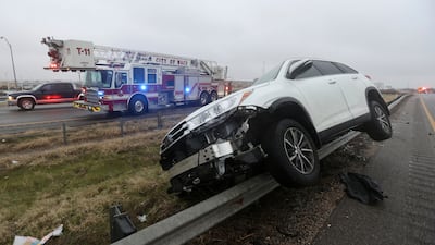 A vehicle rests on a barricade after the driver lost control and slid off Highway 6 on Tuesday in Waco, Texas. Waco Tribune-Herald / AP